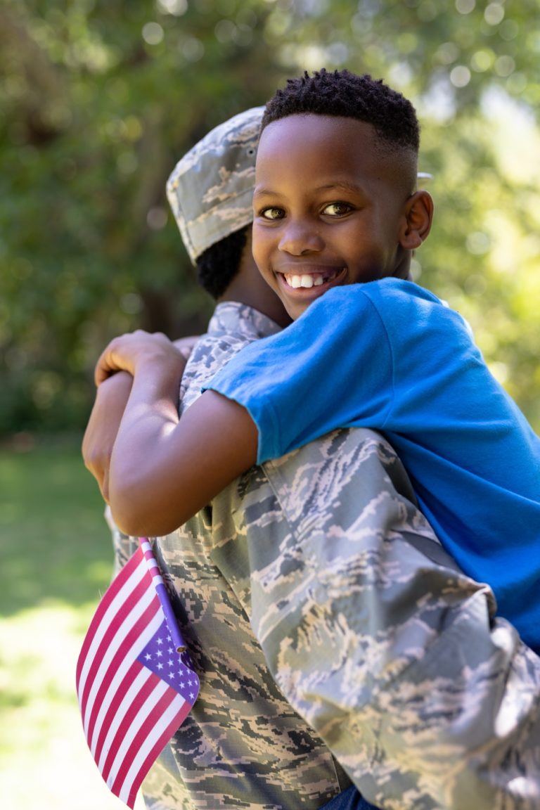 African American man wearing a military uniform holding his son